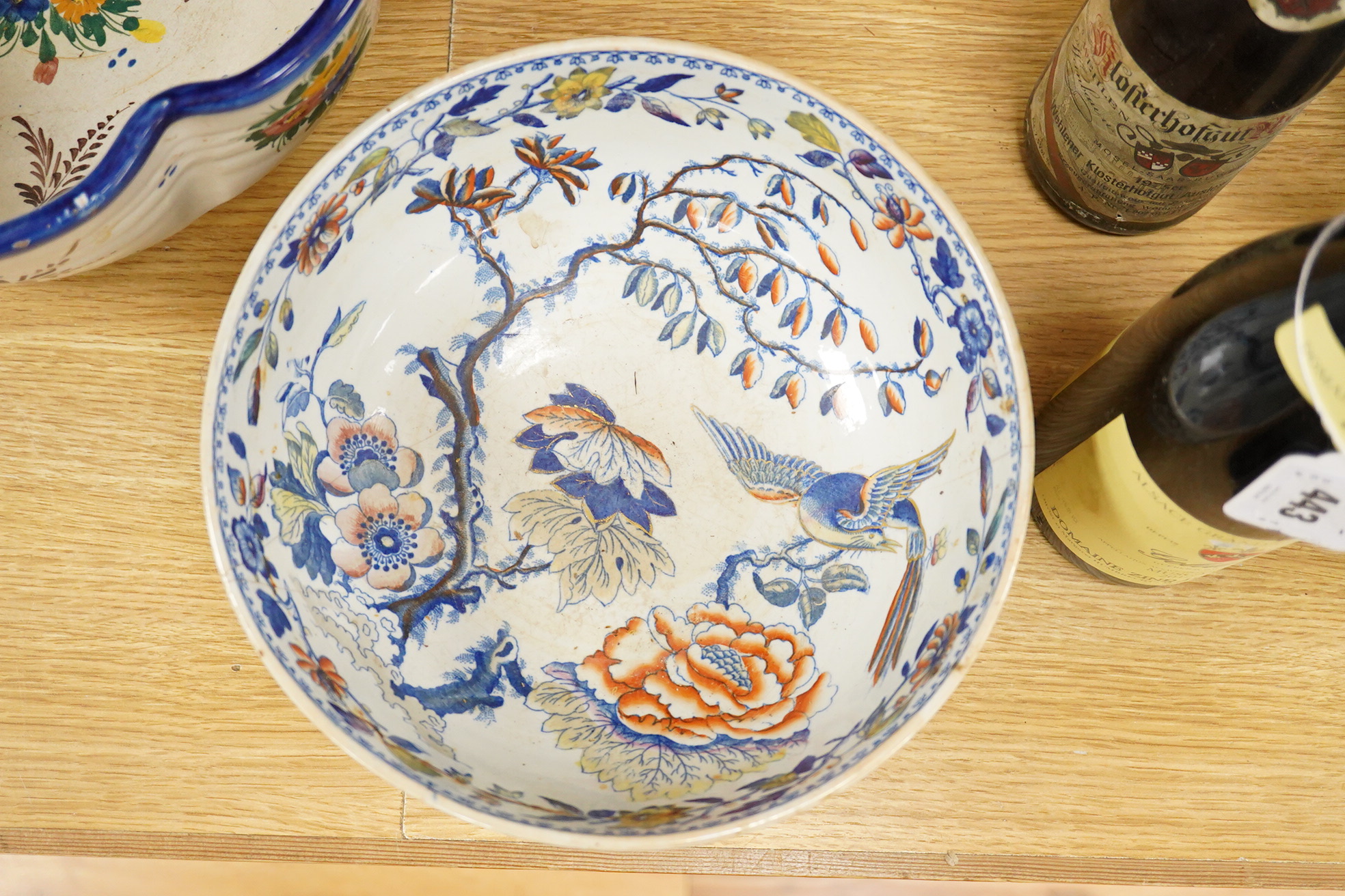 An Italian faience punch bowl painted with flowers and masks and an ironstone pedestal bowl, largest 31cm in diameter